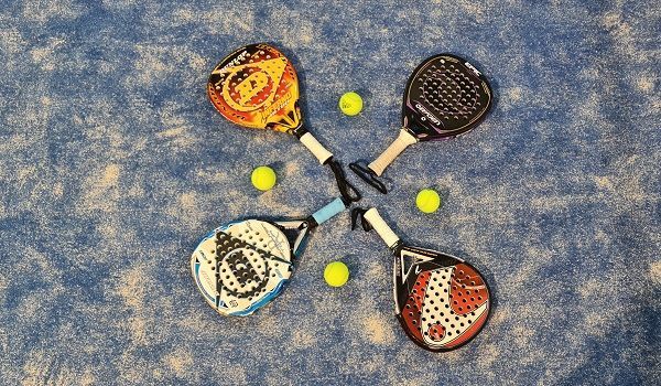4 palas de pádel sobre el suelo de la pista